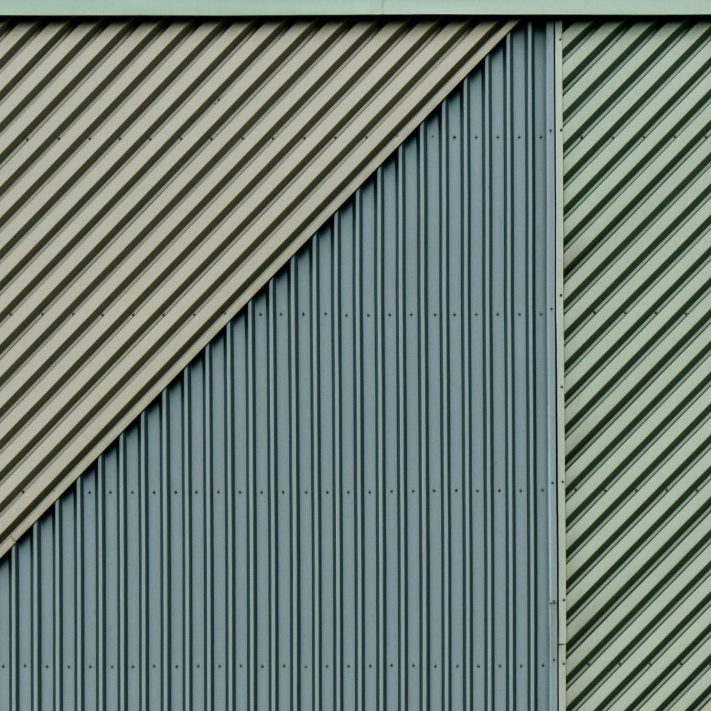 Cladding installation on a warehouse extension with panels being fixed into place
